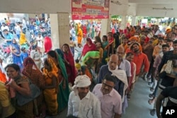 People stand in queue to register outside district hospital in Ballia, Uttar Pradesh state, India, Monday, June 19, 2023.