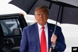Former President Donald Trump walks over to speak with reporters before he boards his plane at Ronald Reagan Washington National Airport, Aug. 3, 2023, in Arlington, Va., after facing a judge on federal conspiracy charges.