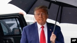 FILE - Former President Donald Trump walks over to speak with reporters before he boards his plane at Ronald Reagan Washington National Airport, Aug. 3, 2023, in Arlington, Va., after facing a judge on federal conspiracy charges.