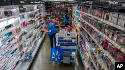 FILE - An employee organizes beauty products inside the Walmart Supercenter in North Bergen, New Jersey, Feb. 9, 2023.