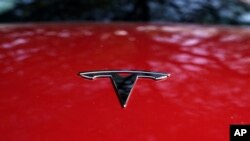 Logo Tesla terpasang pada kendaraan yang ditampilkan di sebuah acara di Austin, Texas, pada 22 Februari 2023. (Foto: AP/Eric Gay)