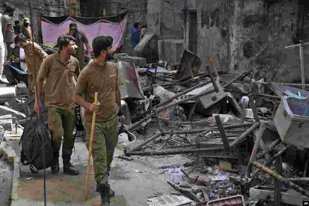 Police look at the rubble of homes vandalized by an angry Muslim mob at a Christian area in Jaranwala, Pakistan, Aug. 17, 2023.