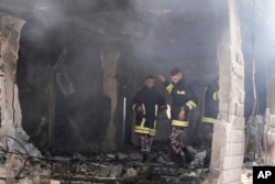 Palestinian firefighters work in the rubble of a home destroyed in an Israeli military operation in the West Bank city of Jenin, July 5, 2024.
