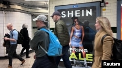 英国伦敦市民走过地铁走道旁中国便宜服装品牌Shein的广告牌。（2024年3月8日）