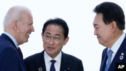 FILE - U.S. President Joe Biden talks with Japan's Prime Minister Fumio Kishida and South Korean President Yoon Suk Yeol, right, ahead of a trilateral meeting on the sidelines of the G7 summit in Hiroshima, Japan, May 21, 2023.