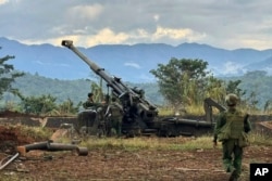 FILE - In this photo provided by the Kokang online media, members of an ethnic armed forces group check weapons the group allegedly seized from Myanmar's army outpost on a hill in Hsenwi township in Shan state, Myanmar, Nov. 24, 2023.