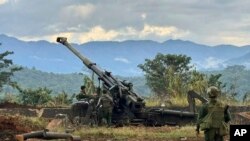 资料照片：一个少数民族武装团体的成员在缅甸掸邦辛威镇的一座山上检查据称从缅甸军队前哨基地缴获的武器。(2023年11月24日)