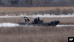 FILE - A police boat searches in Akwesasne, Quebec, March 31, 2023. Eight people died last week while attempting a U.S.-Canada border crossing by boat across the St. Lawrence River.