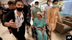 An Australian passenger, center, who was injured on a flight that was battered by severe turbulence, talks to reporters at Samitivej Srinakarin Hospital in Bangkok, Thailand, May 23, 2024.