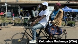 A family cycles in Harare on June 1, 2024. 