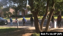Para pedemo memegang poster dan meneriakkan slogan di luar rumah Bob Fu di Midland, Texas dengan menuduh Fu sebagai mata-mata China. (Foto: Bob Fu via AP)