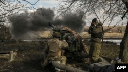 Ukrainian servicemen fire a 105mm Howitzer towards Russian positions, near the city of Bakhmut, March 4, 2023. 