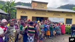 People gather after flooding in western Rwanda, May 3, 2023.