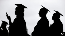 FILE - College graduates line up before the start of commencement in New Jersey, May 17, 2018. More than 40 million Americans will be on the hook for federal student loan payments starting in late August under the terms of a debt ceiling deal approved by Congress last week.