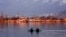 Kashmiri boatmen row their shikara (wooden boats) alongside the famous houseboats in the state’s most popular tourist spot: Dal Lake, Srinagar. (Muzamil Mattoo/VOA)
