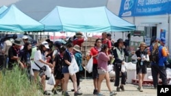 Attendees of the World Scout Jamboree leave a convenience store at the scout camping site in Buan, South Korea, Aug. 2, 2023. 