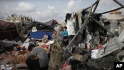 Displaced Palestinians inspect their tents destroyed by Israel's bombardment, adjunct to an UNRWA facility west of Rafah city, Gaza Strip, May 28, 2024.