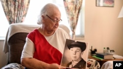Donna Kennedy holds a photo of her cousin, Cpl. Charles Ray Patten who was buried with full military honors, May 20, 2024 in Lawson, Mo.