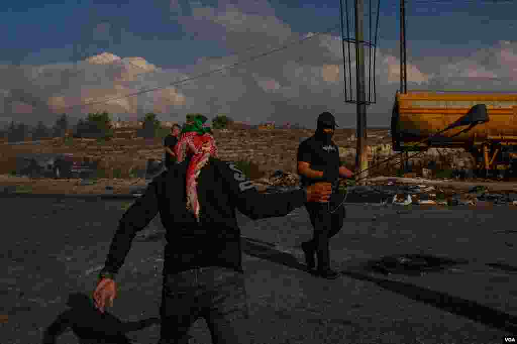 Young Palestians sling rocks at Israeli soldiers on the outskirts of Ramallah, Oct. 18, 2023. (Yan Boechat/VOA)