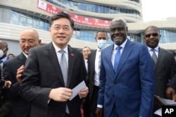 FILE - China's then-Foreign Minister, Qin Gang, left, and African Union Commission chair Moussa Faki Mahamat, right, attend the inauguration of the Africa Centers for Disease Control and Prevention in Addis Ababa, Ethiopia, on Jan. 11, 2023. China has long-established economic interests throughout Africa.