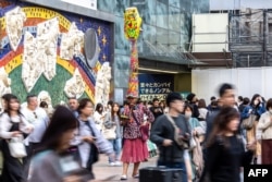 Seorang pria berkostum berdiri di dekat Shibuya Crossing di distrik Shibuya Tokyo, 27 Oktober 2023. (Philip FONG / AFP)