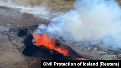 FILE - Lava spurts and flows after the eruption of a volcano in the Reykjanes Peninsula, Iceland, July 12, 2023, as seen in this photo taken from a Coast Guard helicopter.