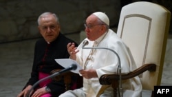 Pope Francis, assisted by Prefect of the Pontifical House, Monsignor Leonardo Sapienza (L), addresses attendees during the weekly general audience, Feb. 15, 2023 at Paul-VI hall in The Vatican.
