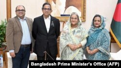 This handout photo released by the Bangladesh Prime Minister's Office on Aug. 10, 2023, shows Akam Sofyol Anam (second from left), his wife, right, and son, left, with Bangladesh Prime Minister Sheikh Hasina (second from right) in Dhaka, Bangladesh, after he was freed.