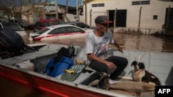 A man navigates on a boat at a flooded street of Eldorado do Sul, Rio Grande do Sul state, Brazil, on May 9, 2024.