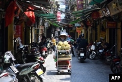 FILE - A vendor sells durian along a street in Hanoi on May 18, 2020. Vietnam has been exporting the fruit to China since September 2022.
