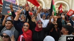 Demonstrators chant slogans while lifting Tunisian and Palestinian flags at a rally organized by the National Salvation Front opposition alliance in Tunis, May 12, 2024, to call for the release of arrested opposition figures. 