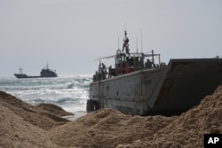 FILE - A U.S. Army landing craft is seen beached in Ashdod, May 26, 2024, after being swept from the temporary pier off the Gaza Strip. The pier, designed to carry aid into Gaza, has been reconnected to the beach, U.S. Central Command said June 7.