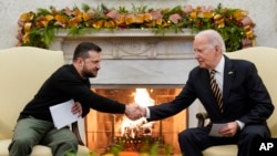 President Joe Biden, right, shakes hands with Ukrainian President Volodymyr Zelenskyy as they meet in the Oval Office of the White House, in Washington, Dec. 12, 2023.