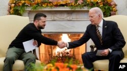 President Joe Biden, right, shakes hands with Ukrainian President Volodymyr Zelenskyy as they meet in the Oval Office of the White House, in Washington, Dec. 12, 2023.