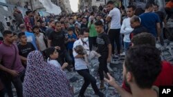 A child is carried from the rubble of a building after an airstrike in Khan Younis, Gaza Strip, Oct. 21, 2023.