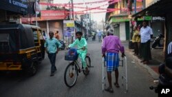 FILE - An elderly man walks through a street in the historic ward of Mattancherry, in Kochi, Kerala state, India, March 6, 2023. 