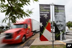 Motorists pass a sign dedicated to former President Jimmy Carter along Jimmy Carter Blvd. in Norcross, Georgia, May 23, 2023.
