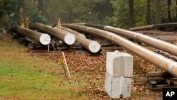 FILE - In this Oct. 22, 2019 photo, pipes lay along a construction site on the Mariner East pipeline in a residential neighborhood in Exton, Pa. The pipeline route traverses those suburbs, close to schools, ballfields and senior care facilities.