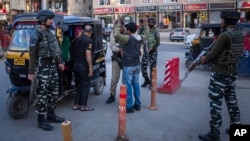 Indian paramilitary soldiers frisk a Kashmiri man at a temporary check point ahead of G-20 tourism working group meeting in Srinagar, Indian-administered Kashmir, May 20, 2023.