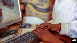 FILE - Two boys use a computer in Nairobi, Kenya, Sept. 29, 2021. Experts in digital technology and communications said on May 7, 2024, that African nations should pass laws to better protect the flow of data across borders while protecting people's privacy and safety.