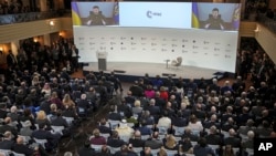 President Volodymyr Zelenskyy of Ukraine speaks from a screen at the Munich Security Conference in Munich, Germany, Feb. 17, 2023. 