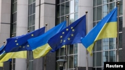 FILE - Flags of Ukraine fly in front of the EU Parliament building on the first anniversary of the Russian invasion, in Brussels, Belgium, Feb. 24, 2023. 