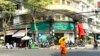 A monk walks in front of a branch office of Amret Microfinance Institution in Daun Penh district, Phnom Penh, Cambodia’s capital, April 5, 2024. (Sun Narin/VOA Khmer)