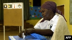 Mwanamke akipiga kura huko Botwana Picha na ALEXANDER JOE / AFP