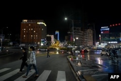 FILE: Pedestrians walk along a street in Sihanoukville late on September 23, 2022.