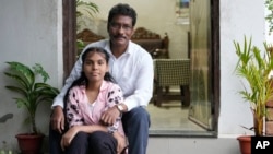 Gautam Dongre, of the National Alliance of Sickle Cell Organizations, sits for a portrait with his daughter, Sumedha, 13, at their residence in Nagpur, India, Wednesday, Dec. 6, 2023. (AP Photo/Ajit Solanki)