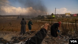 Sejumlah remaja perempuan Palestina tampak mengumpulkan batu untuk dilemparkan ke arah tentara Israel di pinggiran Kota Ramallah di Tepi Barat, pada 18 Oktober 2023. (Foto: VOA/Yan Boechat)