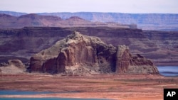 FILE - Low water levels at Wahweap Bay at Lake Powell along the Upper Colorado River Basin are pictured, June 9, 2021, at the Utah and Arizona border at Wahweap, Ariz.