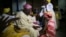 FILE - Sunlola Ogungbadero kneels to receive blessings from her parents during her traditional wedding in Surulere district in Lagos, Nigeria, July 31, 2014.