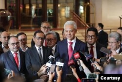 Pasangan capres-cawapres Ganjar Pranowo dan Mahfud MD hari Senin (22/4) bicara pada wartawan sesaat sebelum berangkat ke Mahkamah Konstitusi untuk mendengar putusan atas gugatan mereka. (Courtesy: TPN Ganjar-Mahfud)